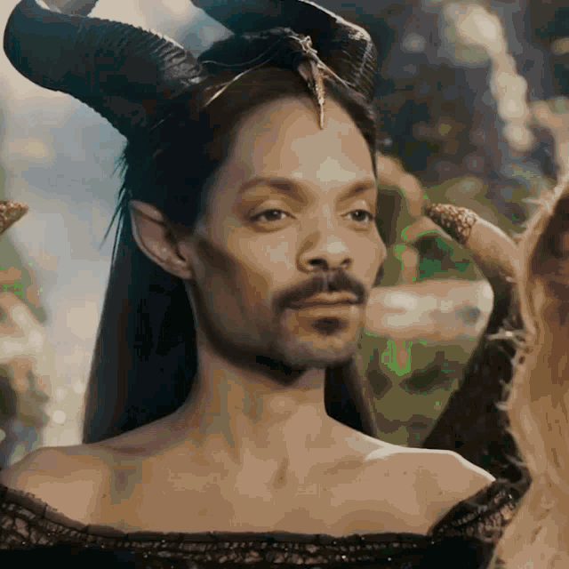 a man with a beard is dressed as a woman with horns on her head