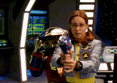 a woman is holding a gun in front of an arcade machine that says " arcade " on it