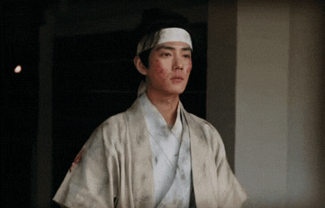 a man with a bandage on his head is wearing a white kimono