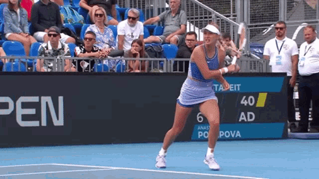 a woman playing tennis on a court with a sign that says pen in the background