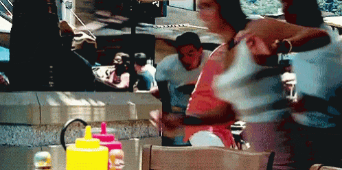 a blurred image of people in a restaurant with a bottle of mustard on the table