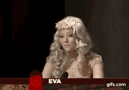 a woman in a wig is talking into a microphone .