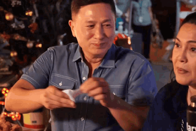 a man in a blue shirt holds a piece of paper