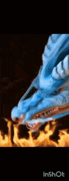 a blue dragon is flying through the air with flames in the background .