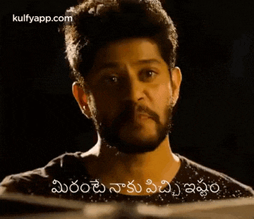 a man with a beard is giving a thumbs up sign in telugu .