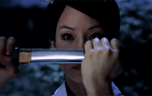 a woman covering her face with a sword