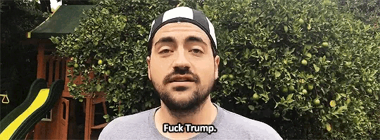 a man wearing a hat says " fuck trump " in front of a playground