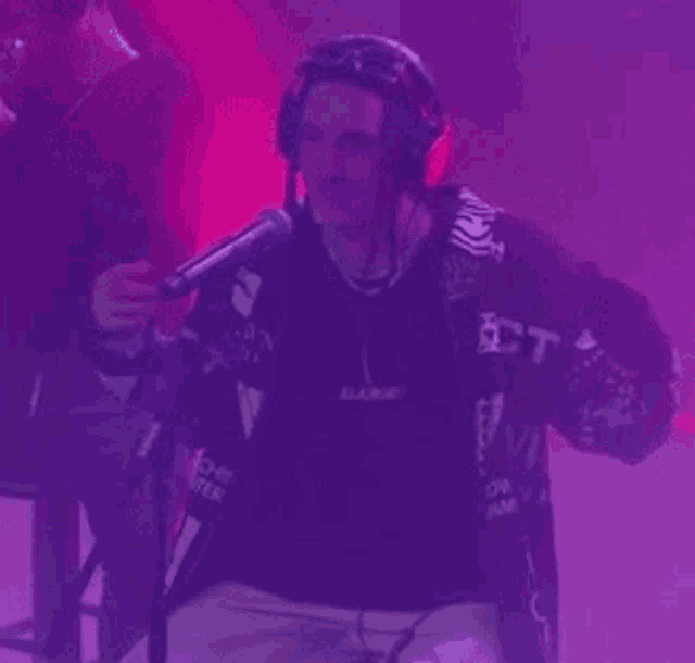 a man wearing headphones is singing into a microphone that says vh