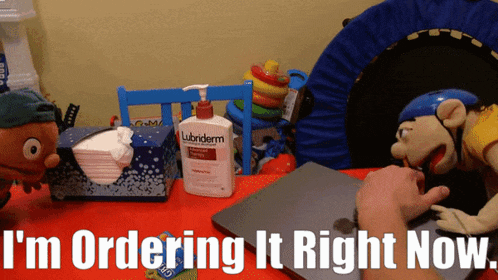 a bottle of lubriderm lotion sits on a table next to a puppet