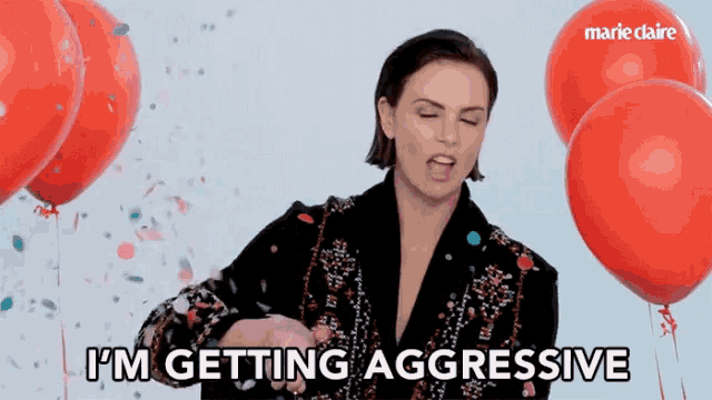 a woman says i 'm getting aggressive with red balloons in the background