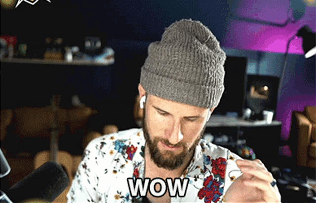 a man with a beard wearing a beanie and a shirt that says wow