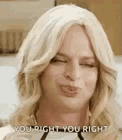 a woman is wearing a wig and making a funny face .