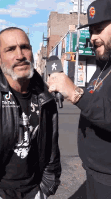 a man is talking to another man with a microphone in his hand .