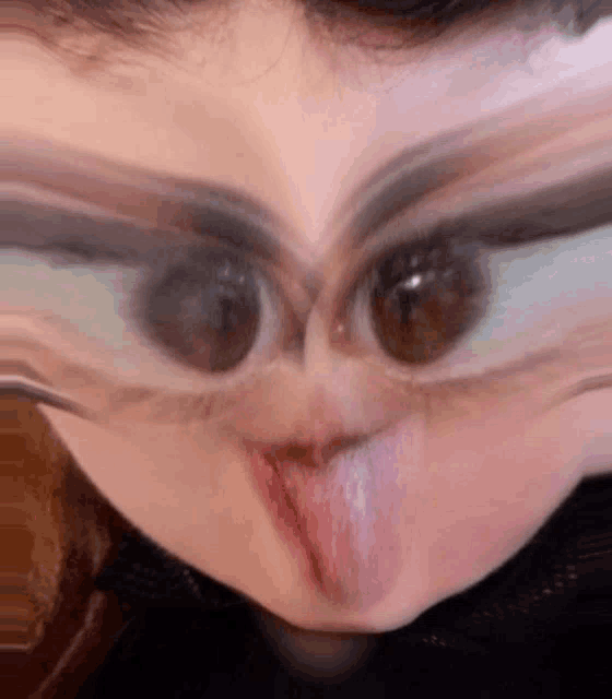 a close up of a person making a funny face with their tongue out