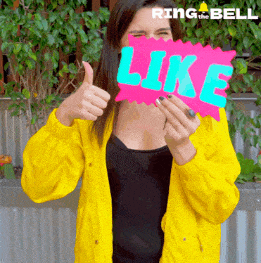 a woman in a yellow jacket is holding up a sign that says like