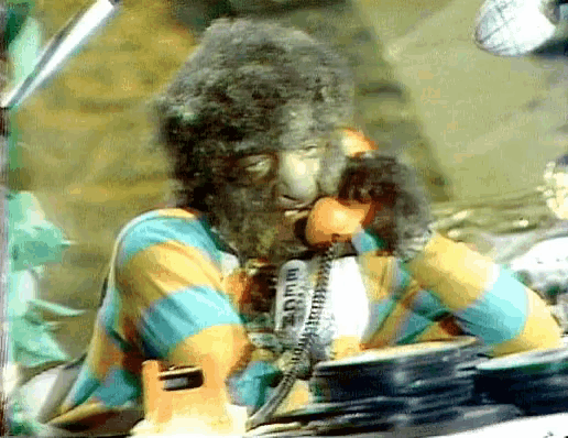 a monkey with a beard is talking on a phone