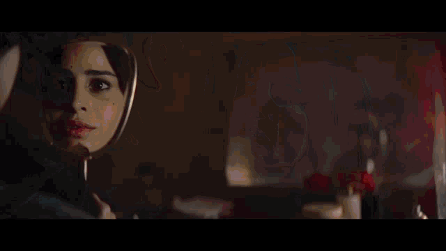 a woman in a red robe is lighting a cigarette with a lighter