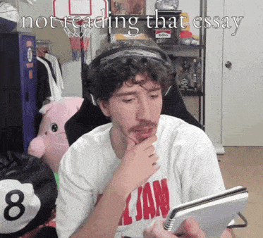 a man wearing a shirt that says ' all jam ' is reading a book