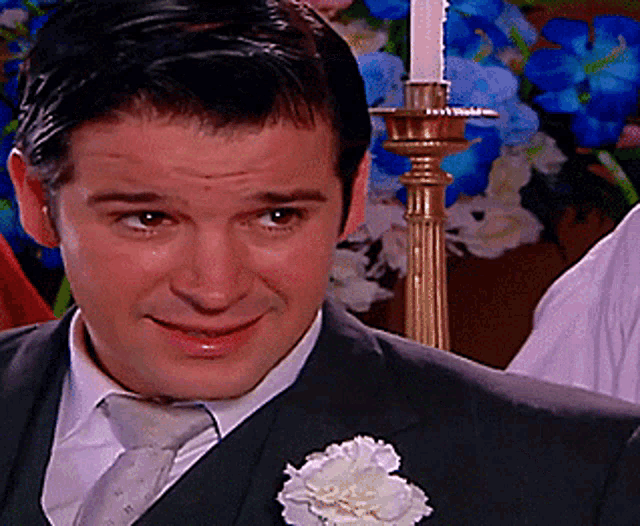 a man in a suit with a flower in his pocket