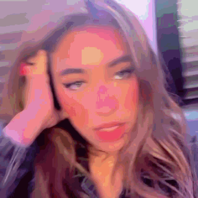 a blurry picture of a woman 's face with a purple background .