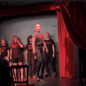 a woman in a netflix t-shirt is dancing on stage