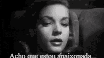 a black and white photo of a woman with the words acho que estou apaixonada written below her .