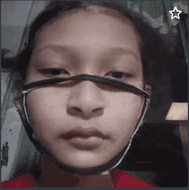 a close up of a girl wearing a mask with a star next to her