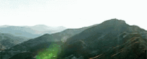 the sun is shining through the trees on the mountains .