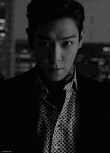 a black and white photo of a man with the name jiyongkun on the bottom right corner