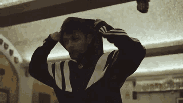 a person wearing a black and white adidas hoodie
