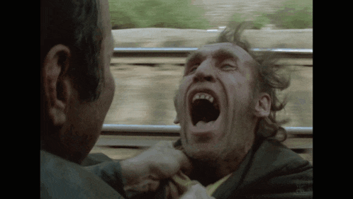 a man with his mouth wide open is being punched by another man