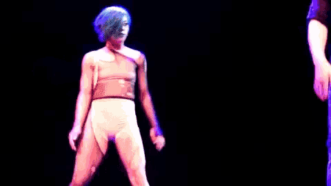 a man and a woman are dancing on a stage and the man is wearing a shirt that says ' reebok ' on it