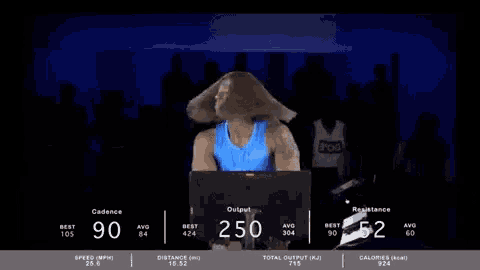 a woman is riding an exercise bike with her hair blowing in the wind
