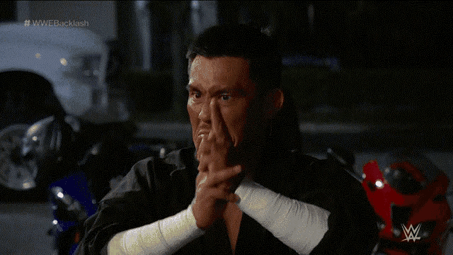 a man with bandages on his wrists is sitting in front of a red motorcycle and a sign that says #wwebacklash