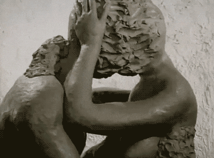 a close up of a statue of a man covering his face
