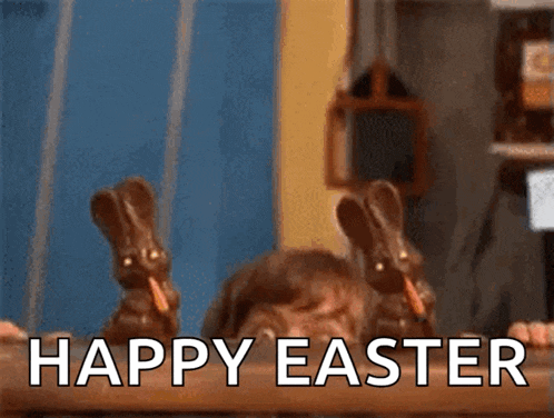 two chocolate bunnies with carrots in their mouths are sitting on a table with the words happy easter written below them