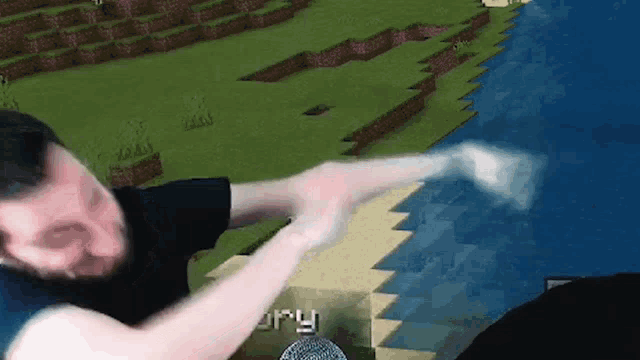 a man is playing a video game in front of a microphone in front of a minecraft world .