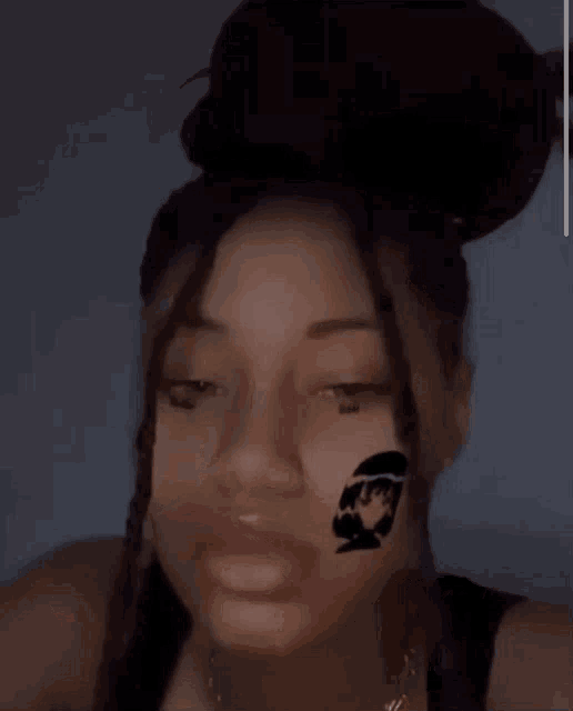 a close up of a woman 's face with a tattoo on her face