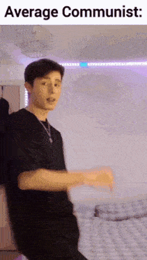 a young man in a black shirt is dancing in a room with the words `` average communist '' above him .