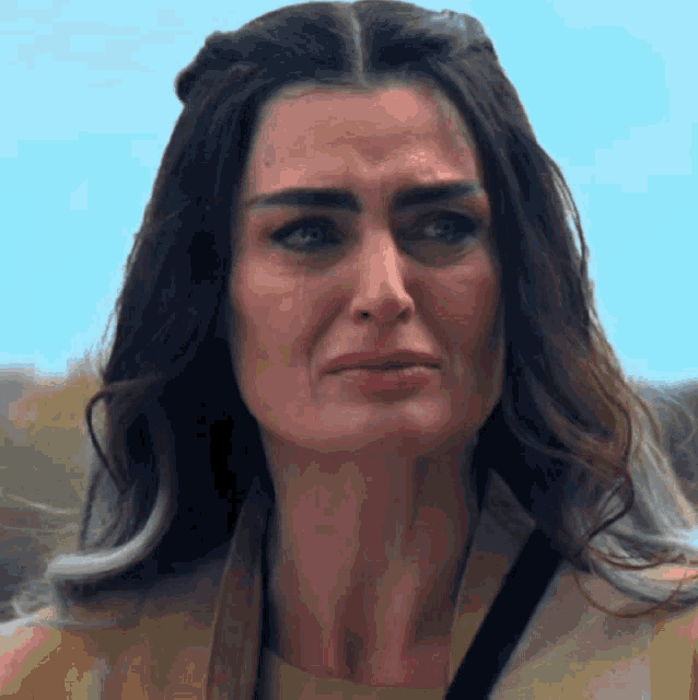 a close up of a woman 's face with a tear coming out of her eye