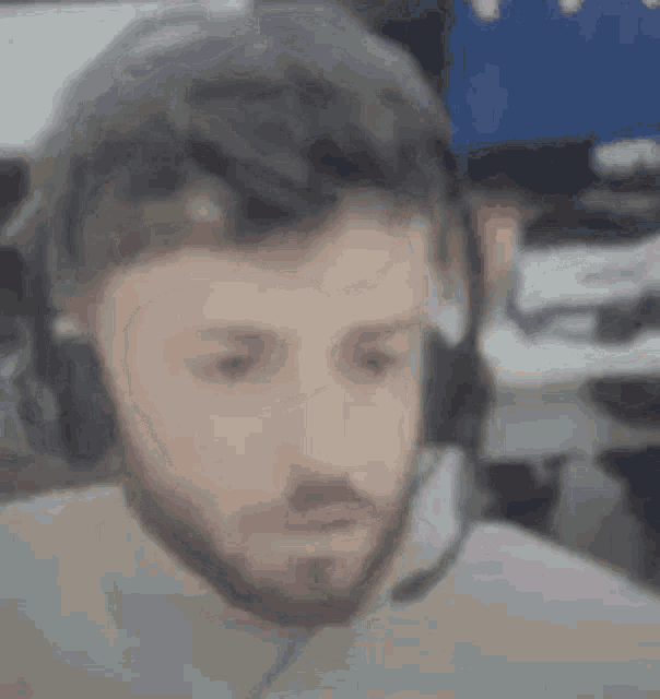 a man with a beard is wearing headphones and a headset .