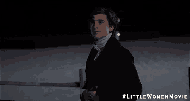 a young man in a suit is smiling in a little women movie