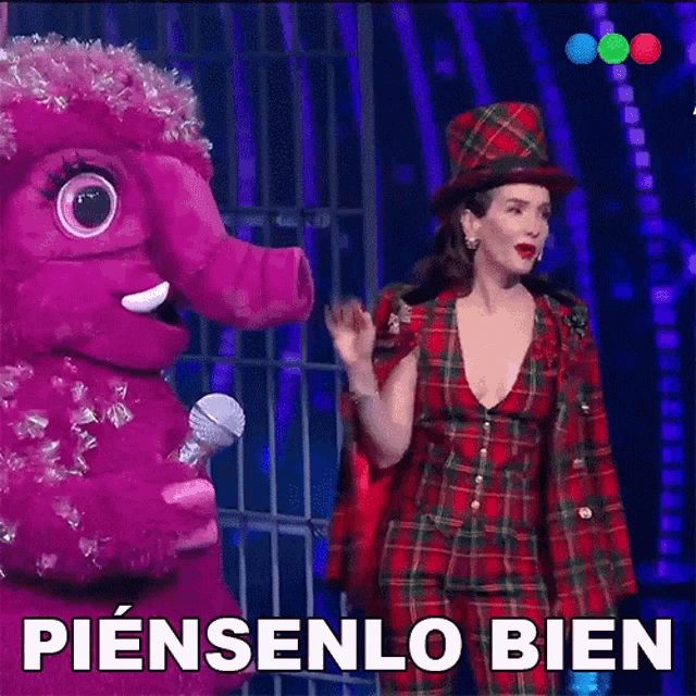 a woman in a plaid suit is standing next to a pink stuffed animal with the words piensenlo bien written on the bottom