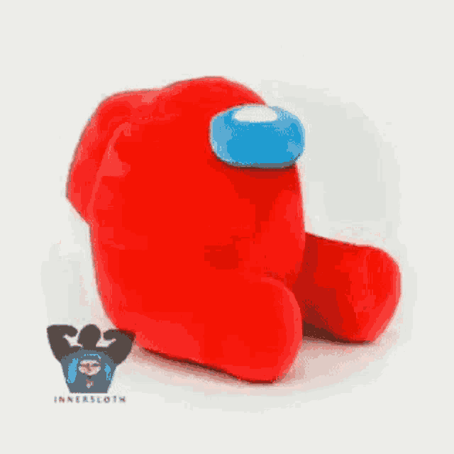 a red stuffed animal with a blue head is sitting on a table .