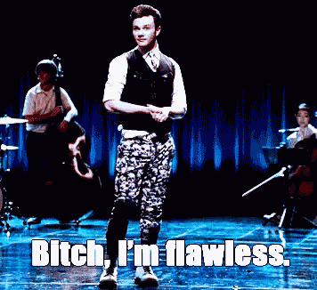 a man is dancing on a stage with the words bitch i 'm flawless behind him