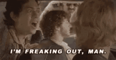 a man is screaming at a woman in a car while a woman looks on .