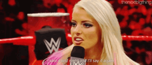 a woman is talking into a microphone in a ring .