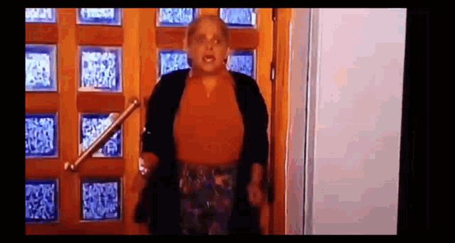 a woman is standing in a doorway holding a railing .