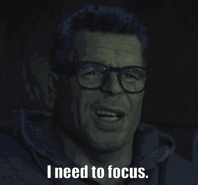a man wearing glasses and a hoodie says i need to focus