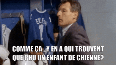 a man in a suit is standing in a locker room with a blue shirt that says exley 1 on it